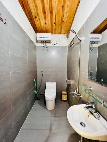 a bathroom with a toilet and a sink at B & M Homes in Tả Van