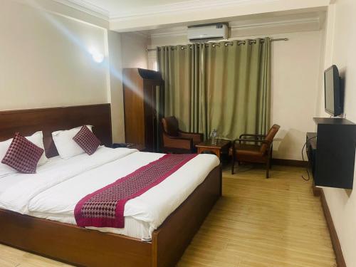 a hotel room with a bed and a television at Hotel Kamal in Kathmandu