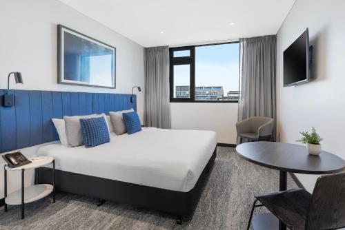 ein Hotelzimmer mit einem Bett und einem Tisch in der Unterkunft Quest Penrith in Penrith