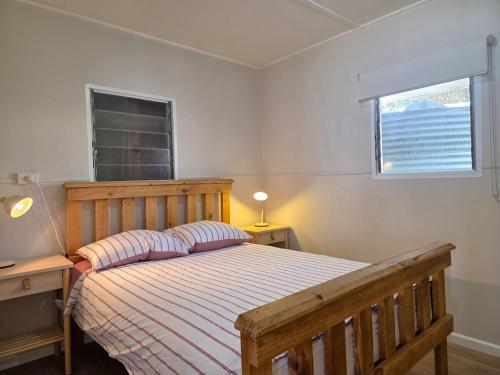 a bedroom with a wooden bed and a window at Jack's Shack in Pine Point