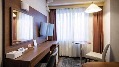 a hotel room with a desk and a mirror at Hotel Excel Okayama in Okayama