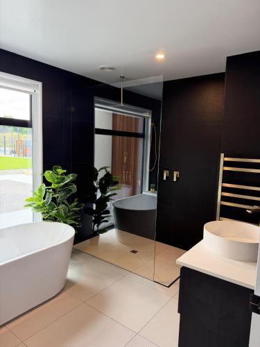 a bathroom with a large tub and a sink and a bath tub at Darfield Retreat in Darfield