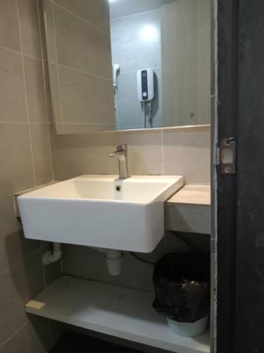 a bathroom with a white sink and a mirror at MF Roxy Beach Townhouse Sematan Private Unit L31 in Sematan