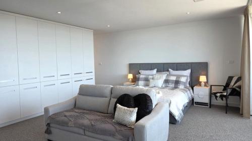 a bedroom with a bed and a couch at Beach & Bubbles in Port Moonta