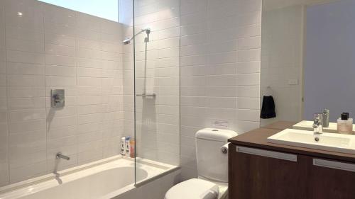 a bathroom with a toilet and a sink and a shower at Beach & Bubbles in Port Moonta