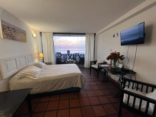 a bedroom with a bed and a desk and a television at Club Colonial Hotel in Huanchaco