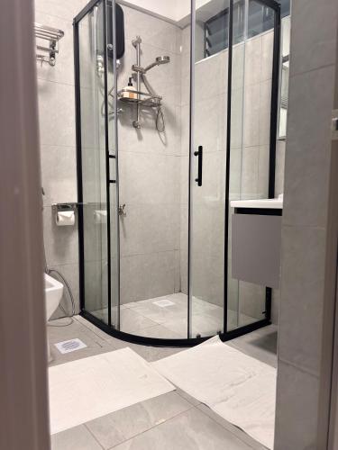 a bathroom with a shower with a glass door at Serenity Spot - Cozy 1 bedroom with AC and Heater with City View in Nairobi, Westlands in Nairobi