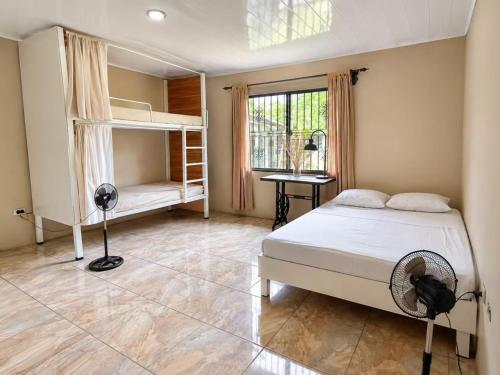 a bedroom with two bunk beds and a fan at La casa de MR in Sarapiquí