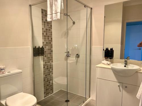 a bathroom with a shower and a toilet and a sink at Caboolture South 3-bedroom Home in Caboolture