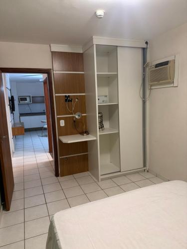 a room with a bed and a glass closet at Flat Beira Mar Caraguatatuba in Caraguatatuba