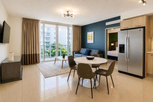 a kitchen and living room with a table and a refrigerator at Habitat Residence in Miami