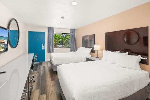 a hotel room with two beds and a mirror at Vista Inn in Vista