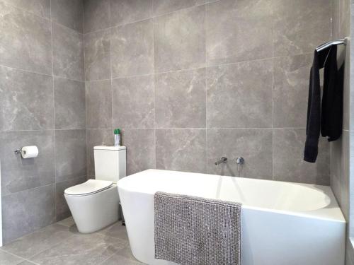 a bathroom with a white tub and a toilet at Belless at Moonta Bay in Port Moonta