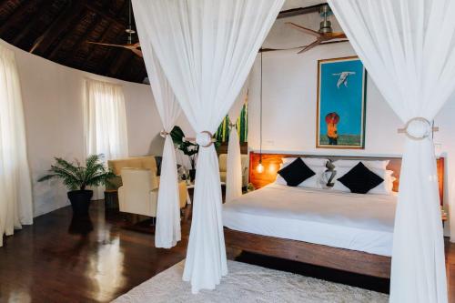 a bedroom with a bed with white curtains at Black Pearl Resort in Espiritu Santo