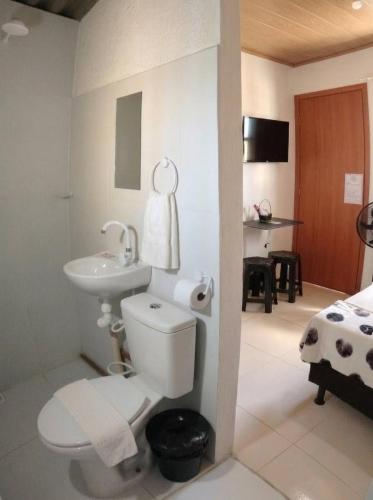 a bathroom with a white toilet and a sink at Quarto 8km Aeroporto MCZ in Maceió