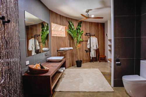 a bathroom with a sink and a toilet and a mirror at Black Pearl Resort in Espiritu Santo