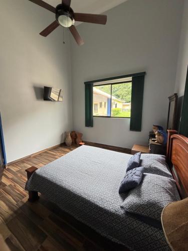 a bedroom with a bed and a ceiling fan at Casa Pacífico Esterillos in Esterillos