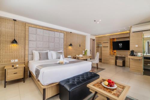 a bedroom with a large bed and a kitchen at 1O1 URBAN Jakarta Thamrin in Jakarta
