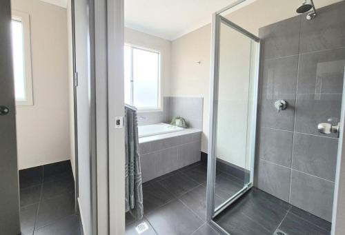 a bathroom with a shower and a tub and a sink at Ramsay House in Port Vincent