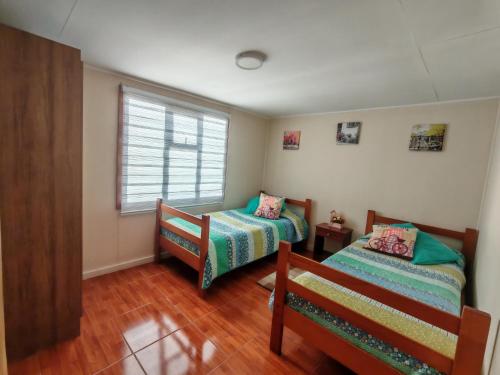 a bedroom with two beds and a window at Julieta House in Puerto Natales
