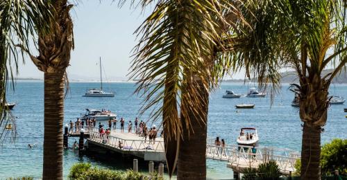 a group of people on a dock with boats in the water at Ramada Resort by Wyndham Shoal Bay in Shoal Bay