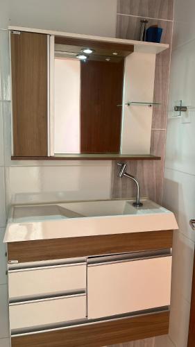 a kitchen with a sink and a mirror at Doce Lar 3 in Pouso Alegre