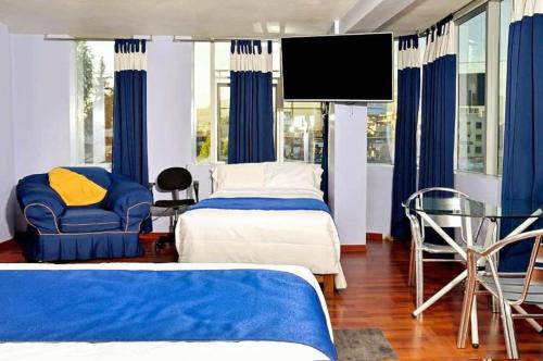 a bedroom with two beds and a flat screen tv at Hotel Inkas in Arequipa