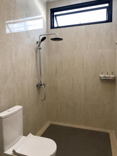 a bathroom with a toilet and a shower with a window at Pondok Biu 2 in Denpasar