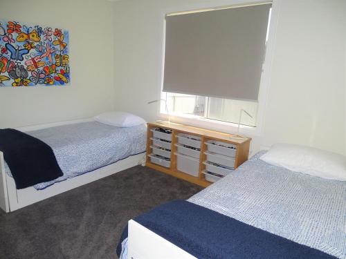 a small bedroom with two beds and a window at Ripplesea in Port Moonta