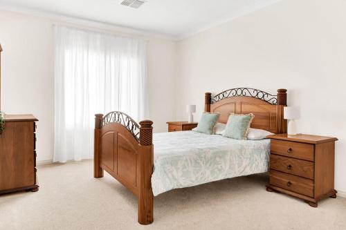 a bedroom with a wooden bed and a wooden dresser at The Stately Way in Wallaroo