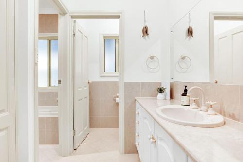 a white bathroom with a sink and a shower at The Stately Way in Wallaroo
