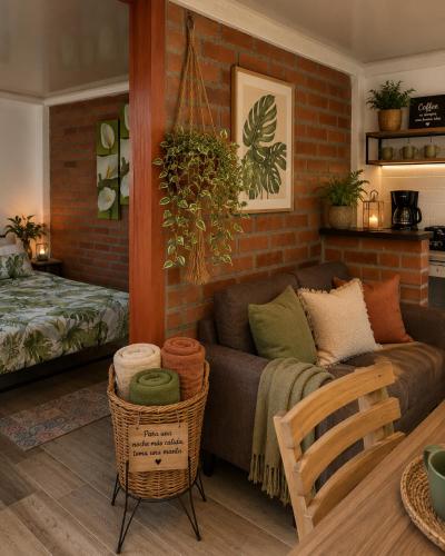a living room with a couch and a brick wall at Apartaestudio Queremal in Papagalleros