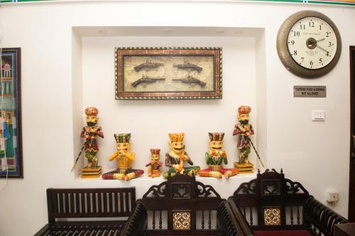 a room with a clock and some figurines on a wall at Hotel Kalyan in Jaipur