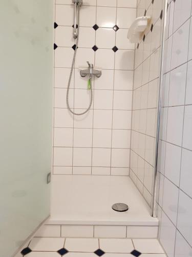 a white tiled shower with a shower at Hygge in Nebel