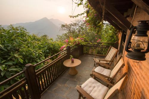 a balcony of a house with chairs and a table at The Famous Farm in Nawākot