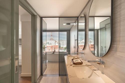 a bathroom with a tub and a sink and a mirror at Solaria d'Oriente Hotel in Hanoi