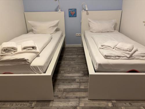 two twin beds in a room with wooden floors at HaK-3 in Wittdün