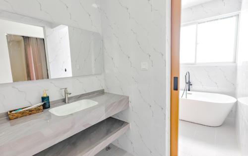 a white bathroom with a sink and a mirror at Tiffany Resident Apartment in Siem Reap