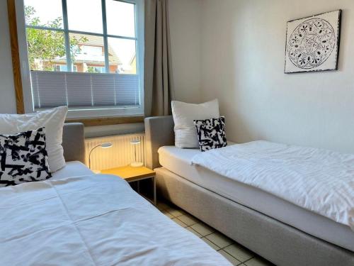 a small room with two beds and a window at Tiramisu in Wittdün
