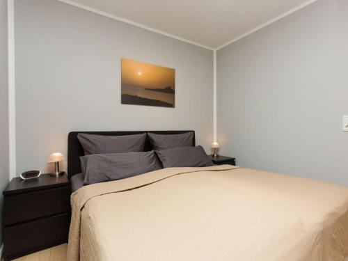 a bedroom with a large bed with two night stands at kleiner-Fiete in Wittdün