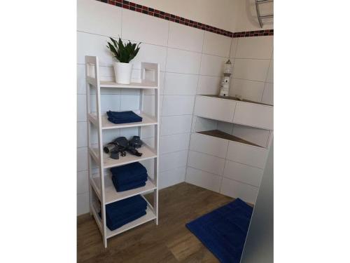 a bathroom with white shelves and blue towels at grosser-Fiete in Wittdün