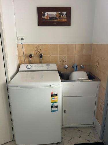 a small kitchen with a sink and a refrigerator at Foundry Cottages in Rutherglen