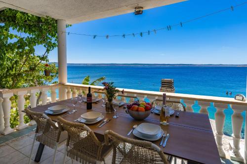 a table on a balcony with a view of the ocean at Seafront Escape - 4BR Beachfront Villa for 8 in Šibuljina