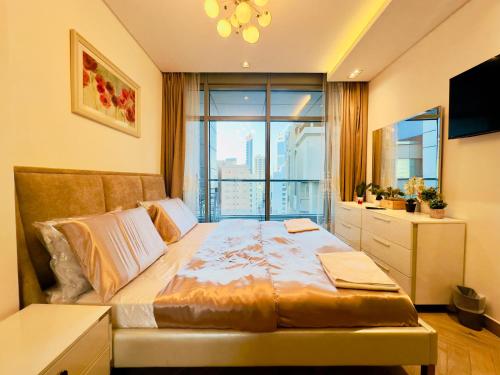 a bedroom with a large bed with a large window at Sea View Apartment in Era View in Manama