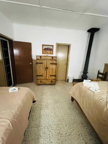 a room with two beds and a wood stove at #4- Rancho Meling in Camalú