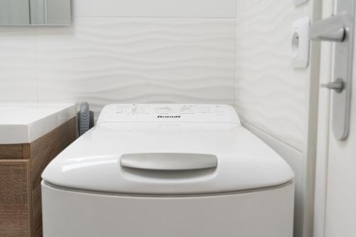a bathroom with a white toilet in a room at A350 Suites - Appartement climatisé, 2 chambres in Colomiers