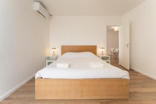 a bedroom with a large bed with white sheets at A350 Suites - Appartement climatisé, 2 chambres in Colomiers