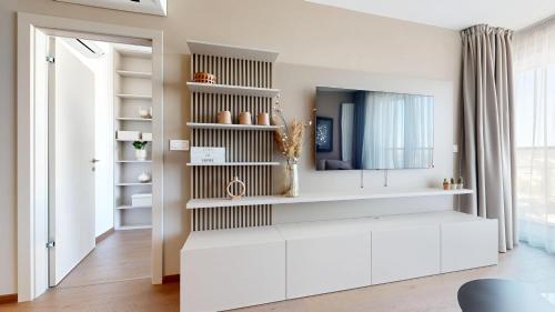 a living room with white cabinets and a mirror at Eurovea Tower Apartments free Parking in Bratislava