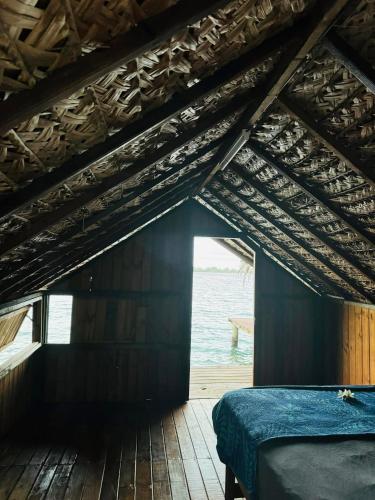 a room with a bed and a view of the water at Faimano Lodge & Car in HUH