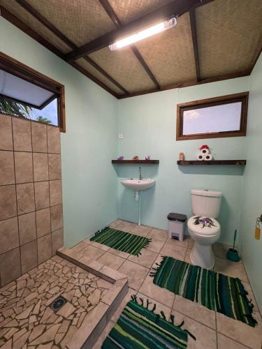 a bathroom with a toilet and a sink at Faimano Lodge & Car in HUH
